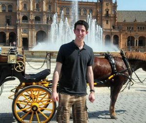 student posing next to horse drawn carriage